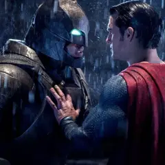 Superman möter en regnig Batman i en tung rustning. Det ser ut som att Batman har varit Batman länge.