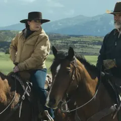 Två ryttare på hästar i en vidsträckt, grönskande terräng med berg i bakgrunden. En kvinna med hatt och en man med cowboyhatt, båda klädda för ridning. En scen som utstrålar känslan av "outer range".
