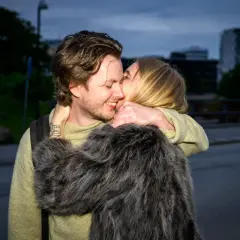 Amanda Romare och Emil omfamnar varandra i skymningen.