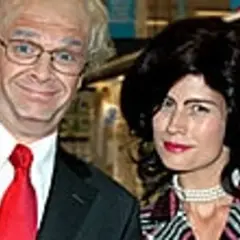 Två personer i kostym och peruk. Mannen har glasögon och röd slips, kvinnan har svart peruk och pärlhalsband. Hey baberiba!