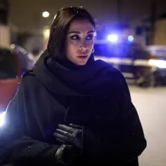 Jana Berzelius står i snö med en polisbil i bakgrunden.