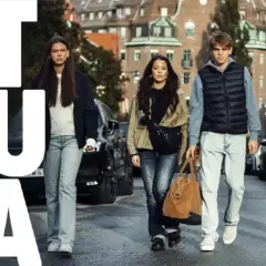 Ungdomar går på gatan, en av dem bär en brun väska. Texten "STRULA" syns stort. SVT-serien som handlar om deras liv.