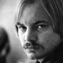Närbild på en man med mustasch och långt hår. Kanske en ung Lars Norén, eller hans fru?