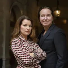 Alexandra Coelho Ahndoril och en man står tillsammans framför en byggnad.