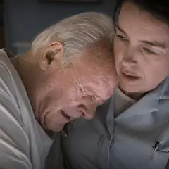 Anthony Hopkins kämpar med demens, hans ansikte uttrycker smärta medan en kvinna tröstar honom.
