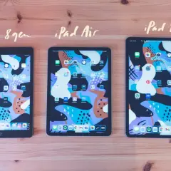 Tre iPads, 8:e gen, Air och Pro, ligger på ett träbord. Alla har samma färgglada bakgrundsbild och appar. Det är lätt att skriva på iPad.