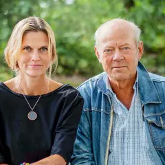 Anna Hedelius och en man sitter utomhus.