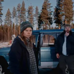 Två personer står vid en blå bil i en snöig skog. Kanske jag for ner till bror serie, och detta är en scen från den.