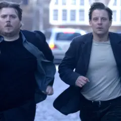 Två män springer i panik genom en stadsgata, i maktens skuggor.