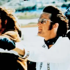 Wycieczka z rollistan i Easy Rider. Dwóch motocyklistów w okularach przeciwsłonecznych i skórzanych rękawiczkach jedzie na motocyklu.