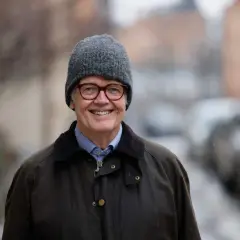 Gunnar Lund ler glatt i grå mössa och jacka, redo för en fråga i Lund.