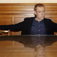 Tony Samuelsson sitter vid ett träbord med en spegelblank yta.