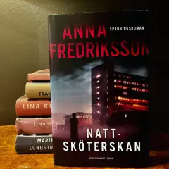 Anna Fredrikssons spänningsroman "Natt-sköterskan" står framför en stapel böcker.