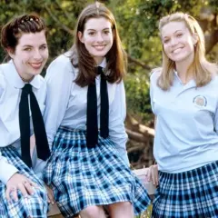 Tre glada tjejer i skoluniformer, som från en prinsessas dagbok 3. De ler mot kameran utomhus.
