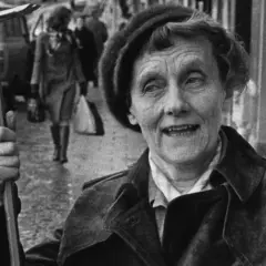 En kvinna med ett brevklo i handen, kanske från en tidig pippi långstrump film 1949, ler mot kameran.