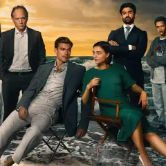 Rollistan i strandhotellet: en familj samlad vid havet, med dramatiska moln och vågor som bakgrund.