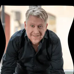 Jesper Ersgård ler mot kameran i en svart skjorta.
