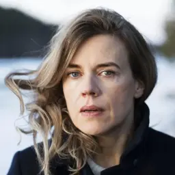 Annika Norlin sjukdom: en kvinna med blont hår och blå ögon tittar rakt fram. Hennes hår blåser i vinden.