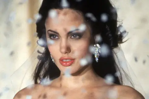 Angelina Jolie med slöja och glittrande örhängen, en ikonisk bild från filmer med Angelina Jolie.