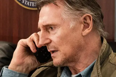 Liam Neeson i liam neeson senaste film, han pratar i en telefon med en intensiv blick.