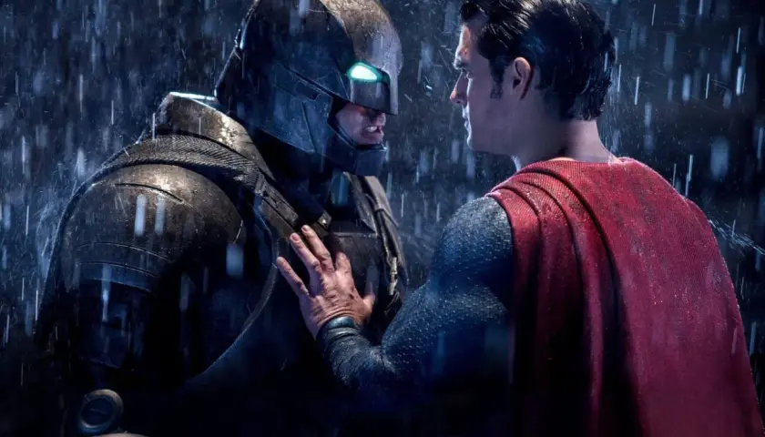 Superman möter en regnig Batman i en tung rustning. Det ser ut som att Batman har varit Batman länge.