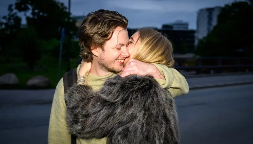 Amanda Romare och Emil omfamnar varandra i skymningen.