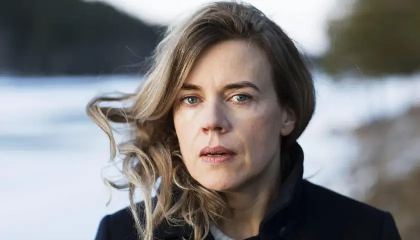 Annika Norlin sjukdom: en kvinna med blont hår och blå ögon tittar rakt fram. Hennes hår blåser i vinden.