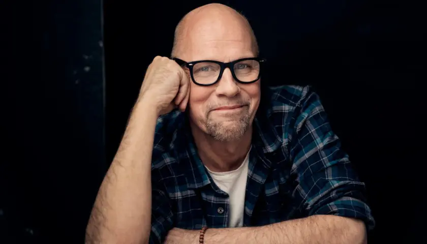 Tomas Tivemark, en skallig man med glasögon och rutig skjorta, lutar sig mot sin hand.