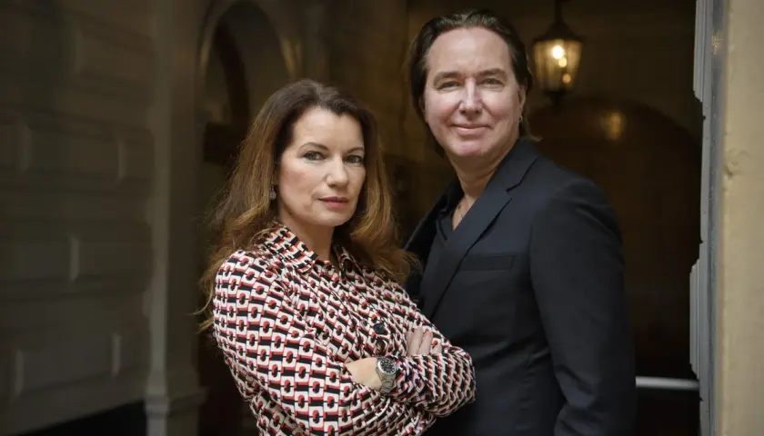 Alexandra Coelho Ahndoril och en man står tillsammans framför en byggnad.