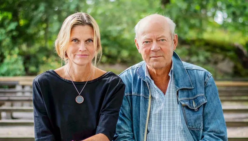 Anna Hedelius och en man sitter utomhus.