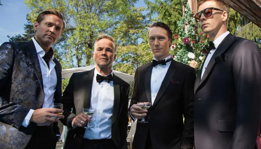 Fyra män i smoking med drinkar. En av dem, en skådespelare, ser ut att vara redo för sin exit.