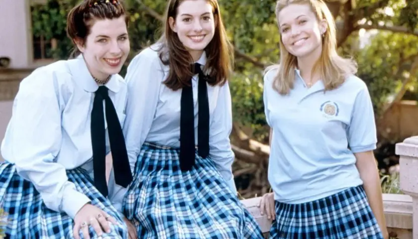 Tre glada tjejer i skoluniformer, som från en prinsessas dagbok 3. De ler mot kameran utomhus.