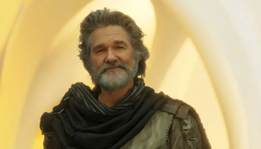 Kurt Russell med grått hår och skägg, klädd i en mörk sjal och rustning. En ikonisk skådespelare som syns i många filmer med Kurt Russell.