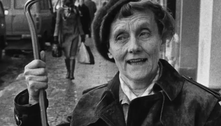 En kvinna med ett brevklo i handen, kanske från en tidig pippi långstrump film 1949, ler mot kameran.
