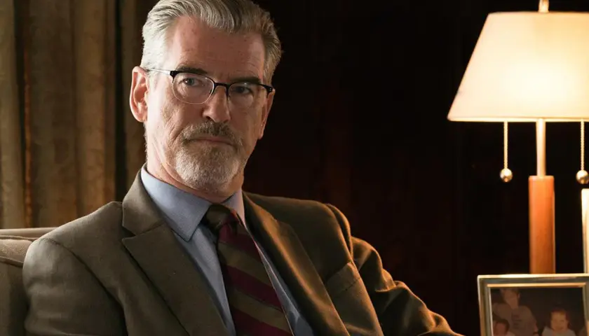 Pierce Brosnan i en kostym, med glasögon och skägg. En scen från "Spinning Man" recension.