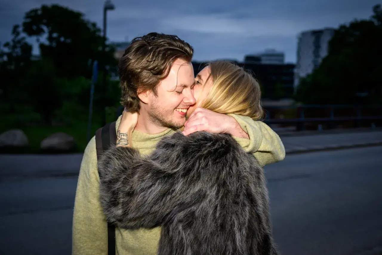 Amanda Romare och Emil omfamnar varandra i skymningen.