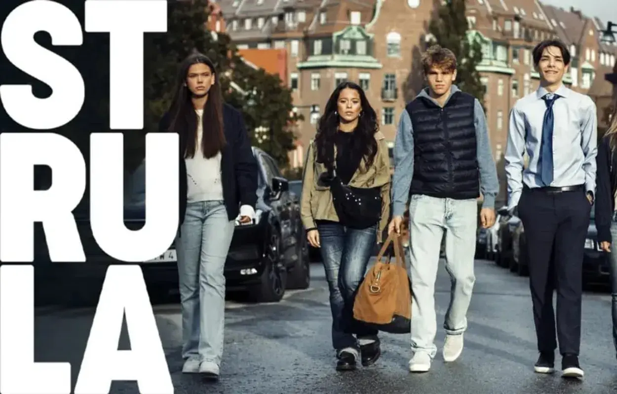 Ungdomar går på gatan, en av dem bär en brun väska. Texten "STRULA" syns stort. SVT-serien som handlar om deras liv.