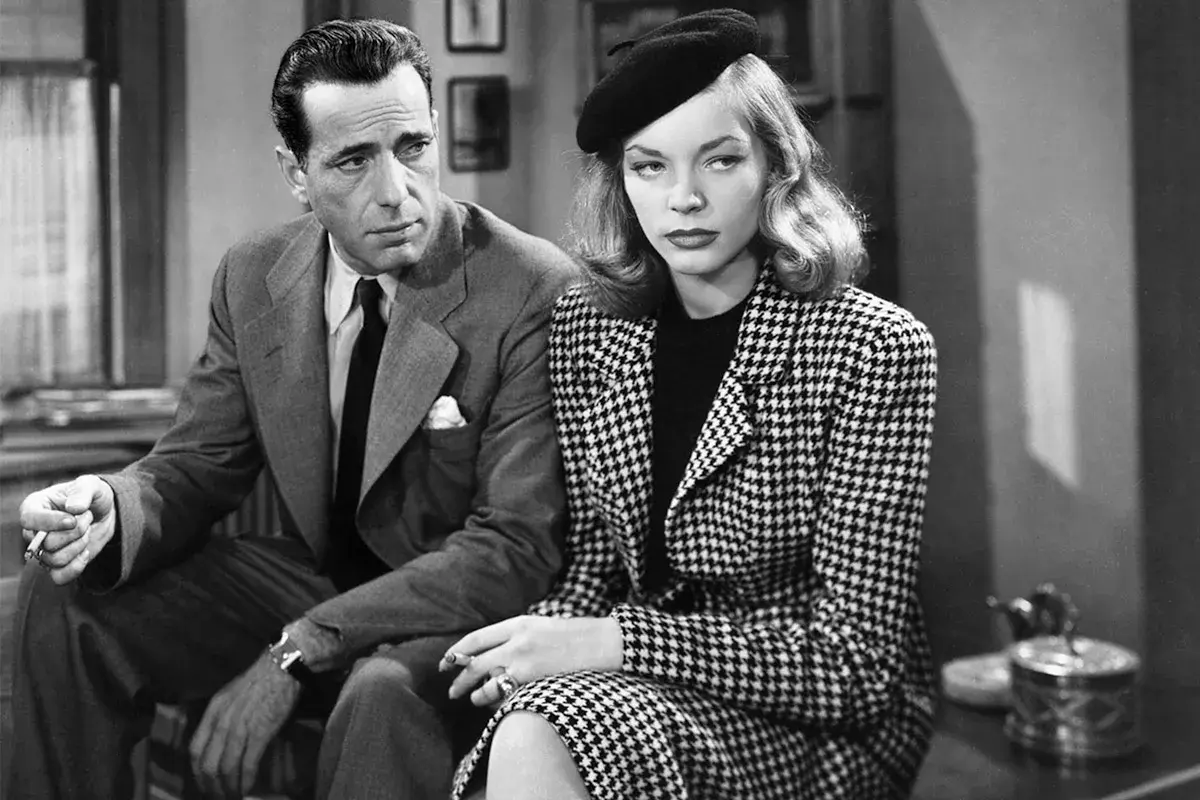 Humphrey Bogart och Lauren Bacall i "The Big Sleep". Hon bär en rutig dräkt och basker, han en kostym och slips.