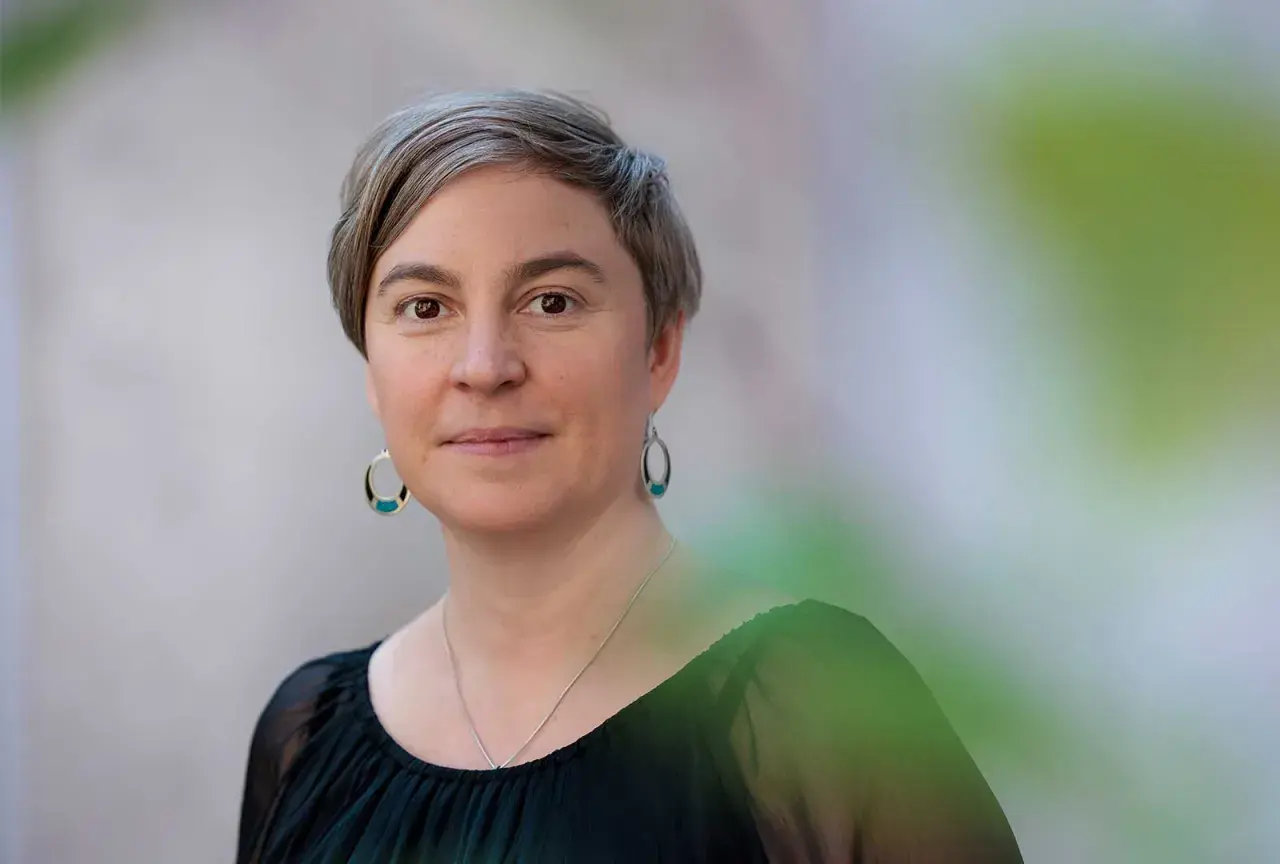 Elin Boardy, med kortklippt grått hår och ovala örhängen, ler mjukt mot kameran.
