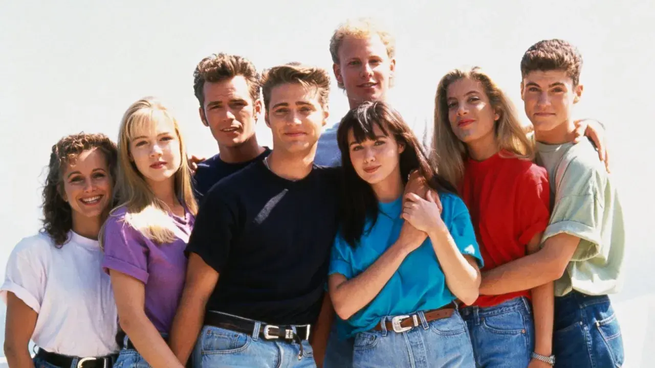 En grupp unga vänner poserar glatt, en ikonisk bild från tv-serier 90-talet.