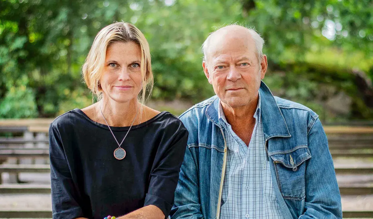 Anna Hedelius och en man sitter utomhus.