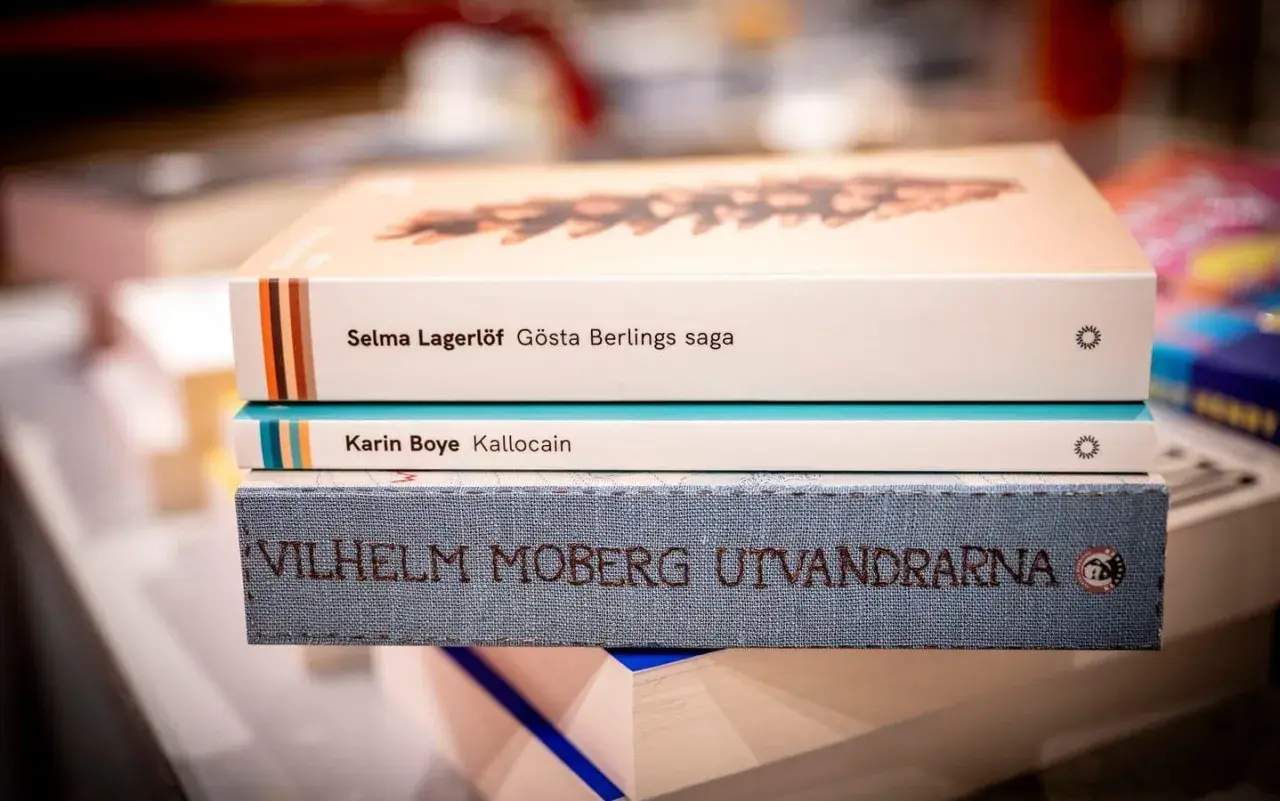 En stapel böcker med Selma Lagerlöf, Karin Boye och Vilhelm Moberg. Ur ett annat person perspektiv ser man titlarna tydligt.