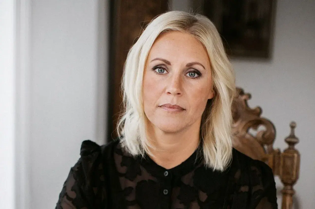 Porträtt av linda ståhl med blont hår och blå ögon, klädd i en svart blus.