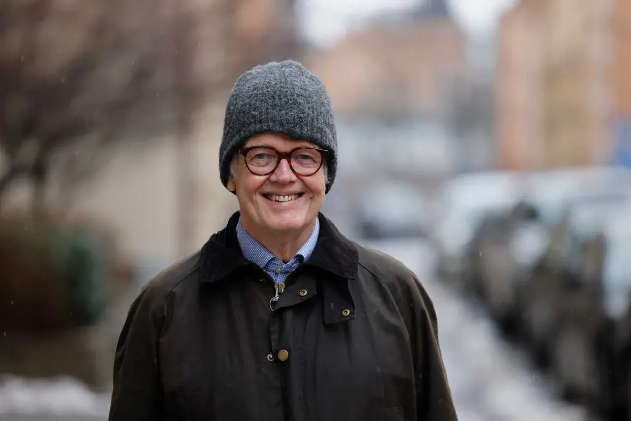 Gunnar Lund ler glatt i grå mössa och jacka, redo för en fråga i Lund.