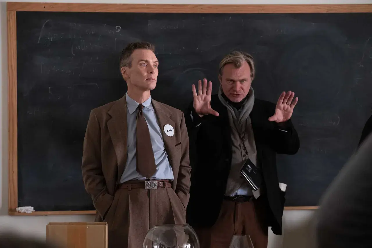 Cillian Murphy och Christopher Nolan diskuterar rollistan i Oppenheimer framför en griffeltavla med formler.