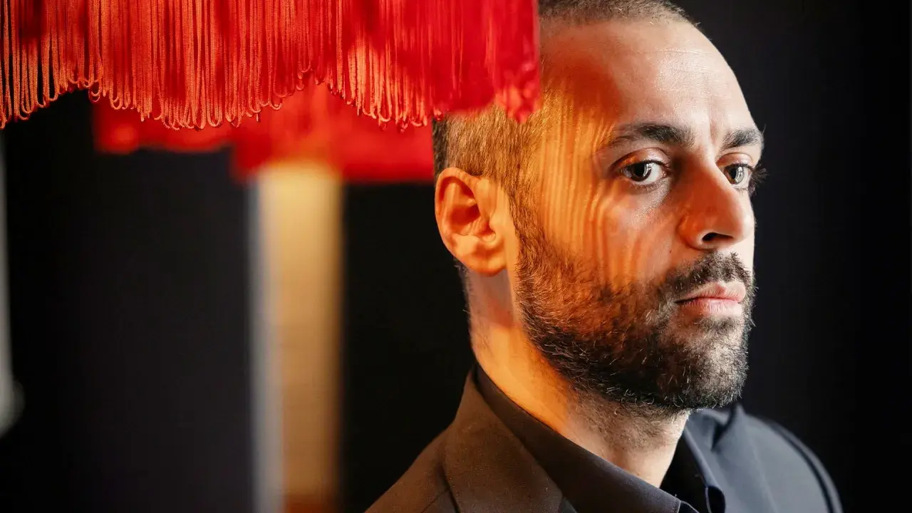 Ardalan Esmaili, med skuggor från en röd lampa som faller över hans ansikte.