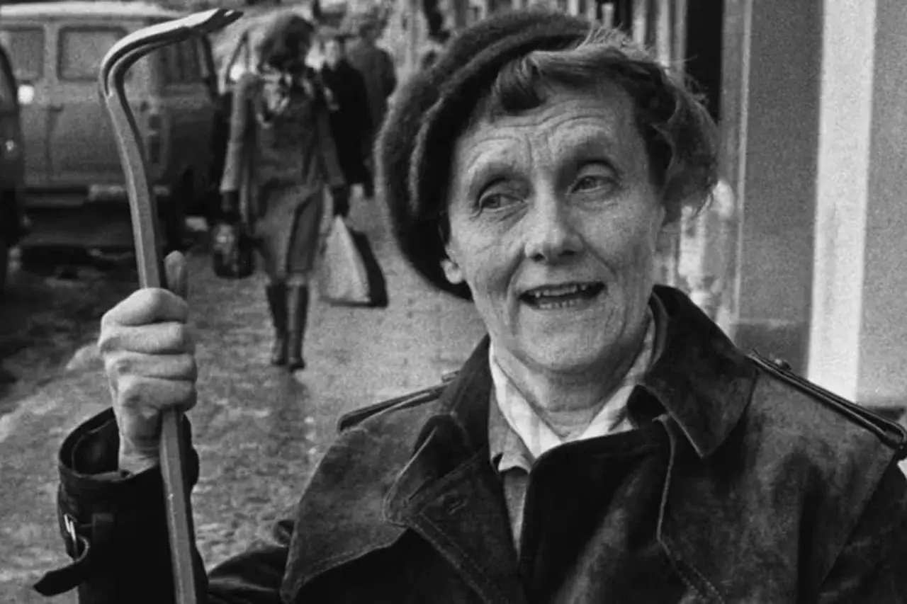 En kvinna med ett brevklo i handen, kanske från en tidig pippi långstrump film 1949, ler mot kameran.