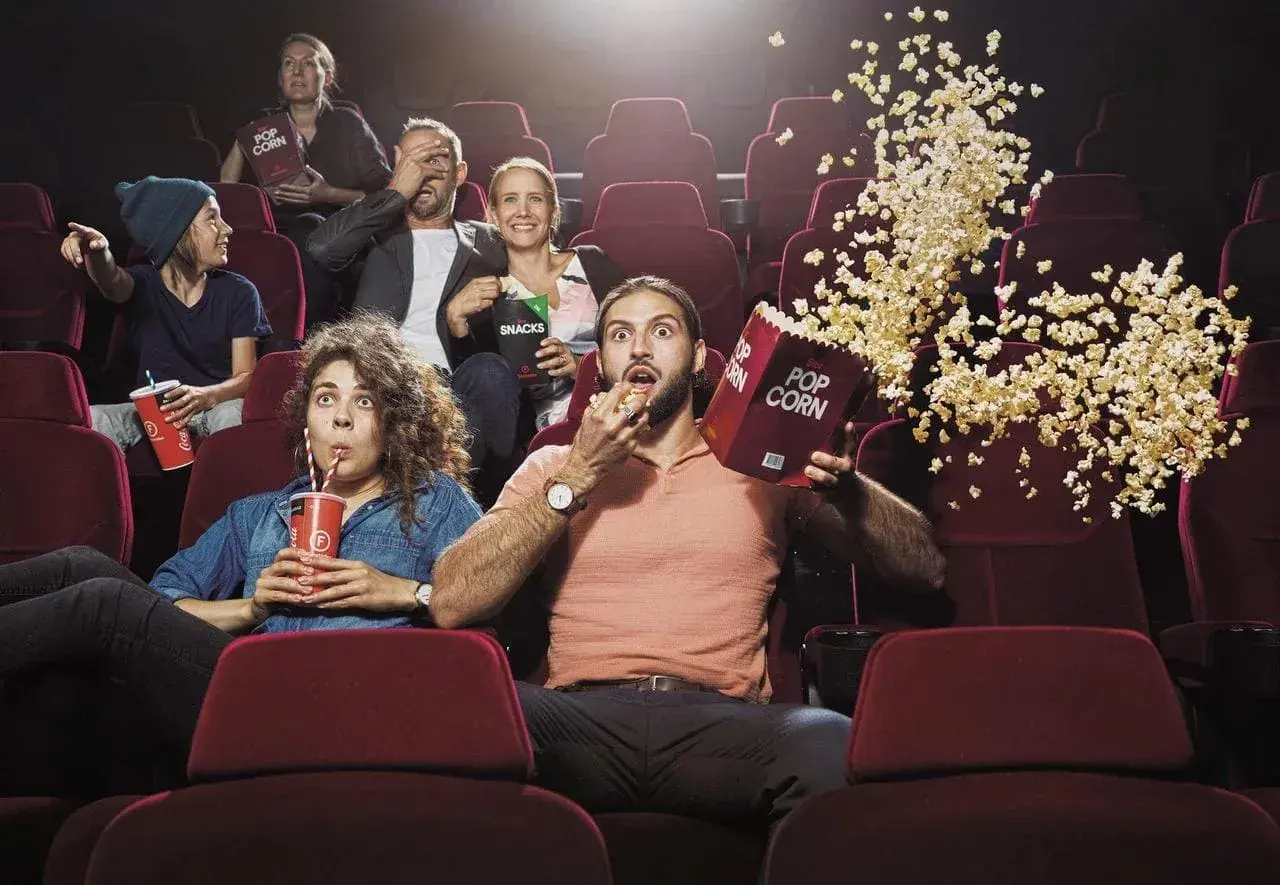 En grupp människor i en biosalong, några med popcorn som flyger, upplever en spännande film. Kanske en av de mest sedda filmerna i Sverige genom tiderna!