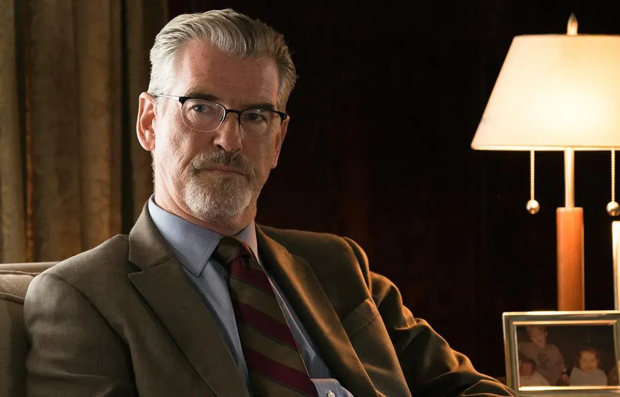 Pierce Brosnan i en kostym, med glasögon och skägg. En scen från "Spinning Man" recension.