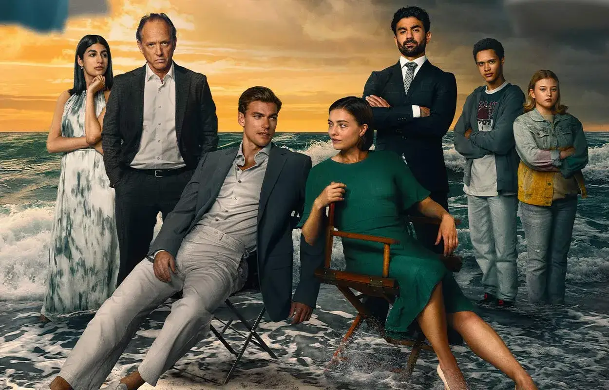 Rollistan i strandhotellet: en familj samlad vid havet, med en dramatisk solnedgång i bakgrunden.